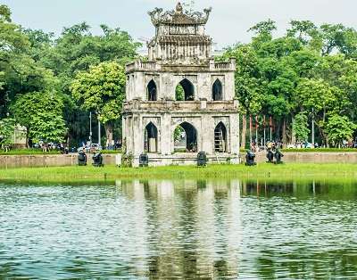 White building near water reservoir in Hanoi is a major tourist site and a milestone in Hanoi Tourism