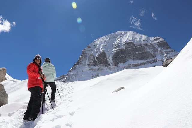 man in black jacket and black pants walking on snow covered mountain during daytime