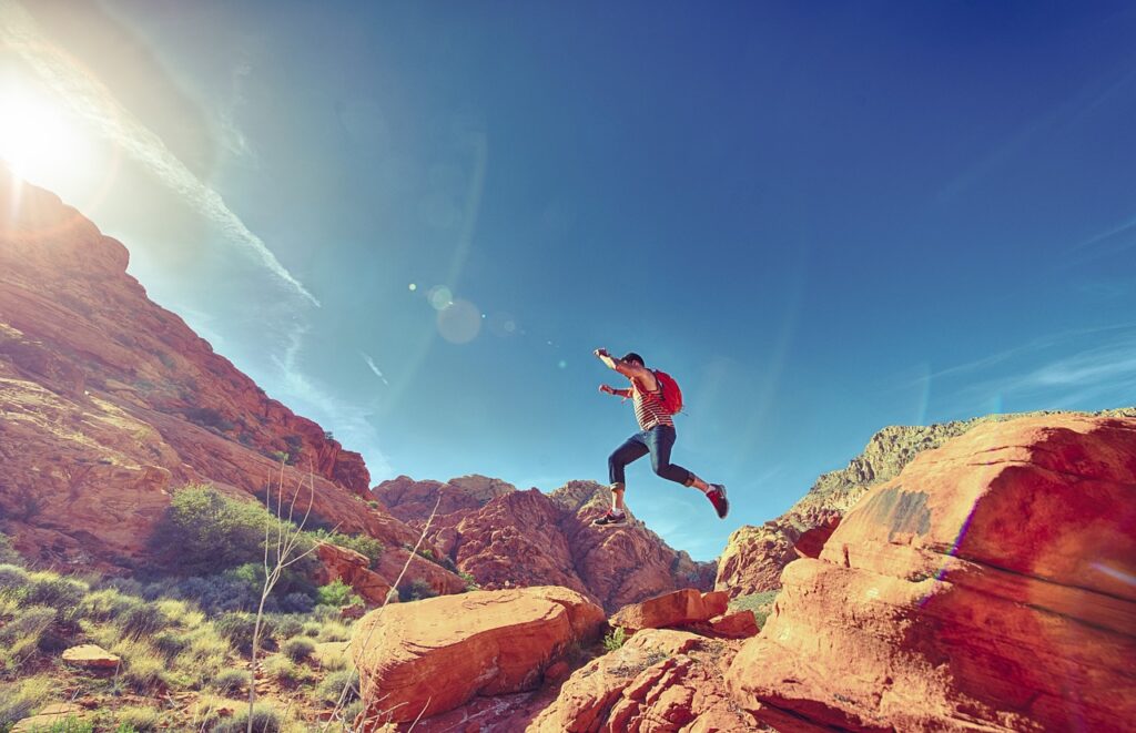 man climbing over the mountains while hiking in california