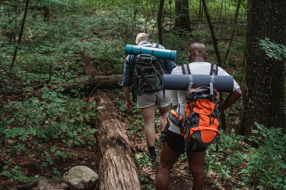 two backpackers hiking through deep forest in Yosemite National park