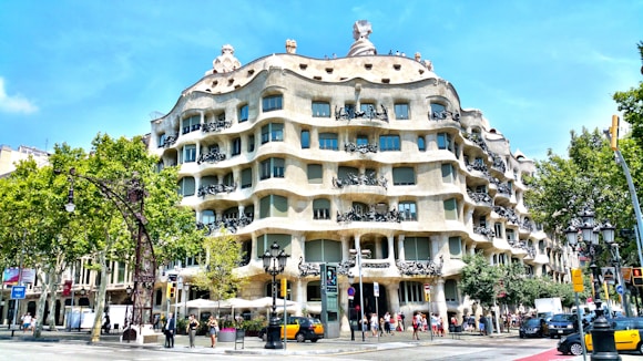 people walking on sidewalk near building named Casa Mila in Barcelona