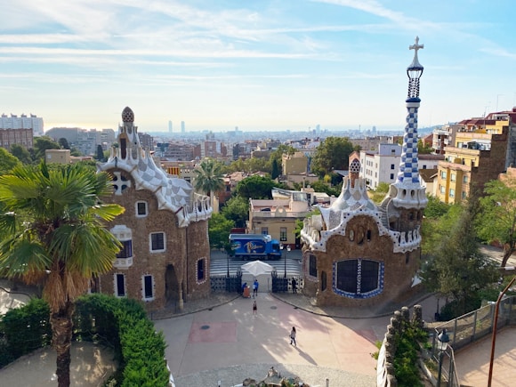 an aerial view of a building with a clock tower in the background of park guell considered one of the best places in barcelona